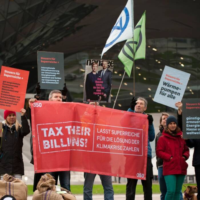 People take action in Germany with 350's Tax Their Billions campaign, calling for wealth taxes on the super-rich to fund climate action and more.